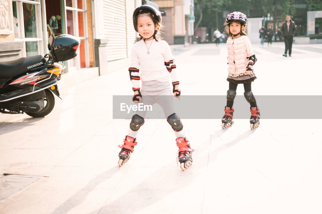 CHILDREN PLAYING ON STREET AGAINST THE SKY