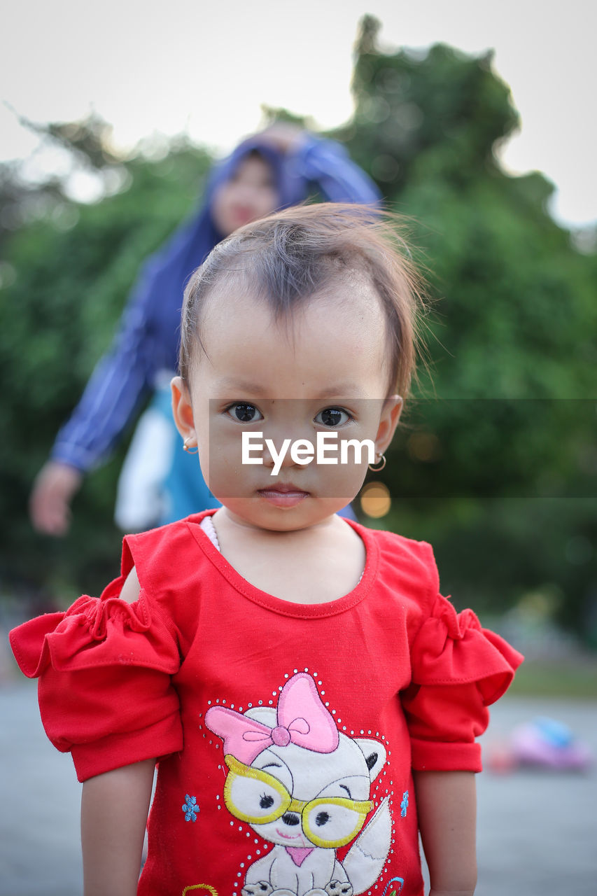 Portrait of cute girl with woman in background