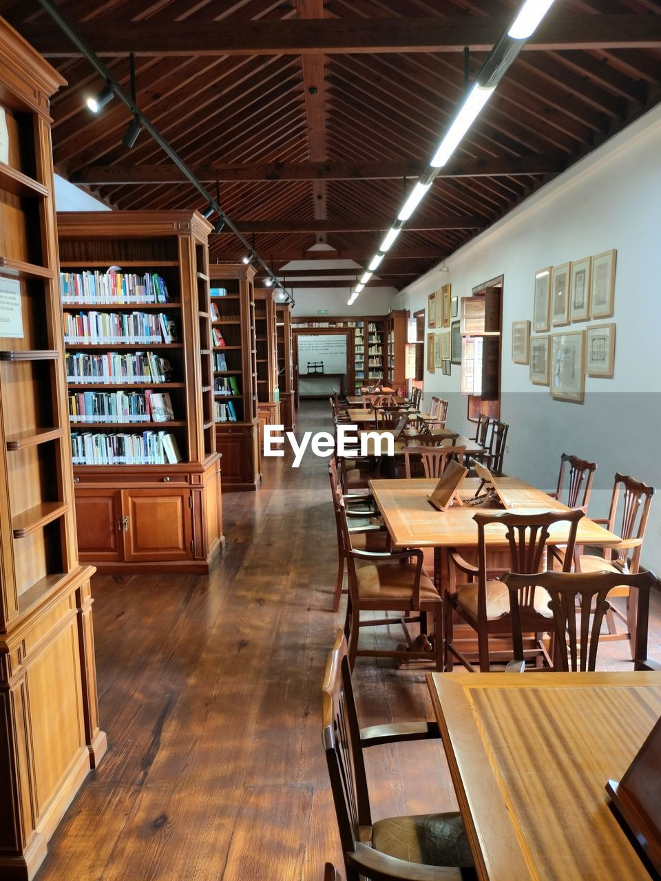 indoors, seat, wood, table, room, chair, library, shelf, interior design, architecture, flooring, bookshelf, furniture, hardwood floor, no people, business, book, bookcase, domestic room, education, absence, food and drink, publication, home interior, building