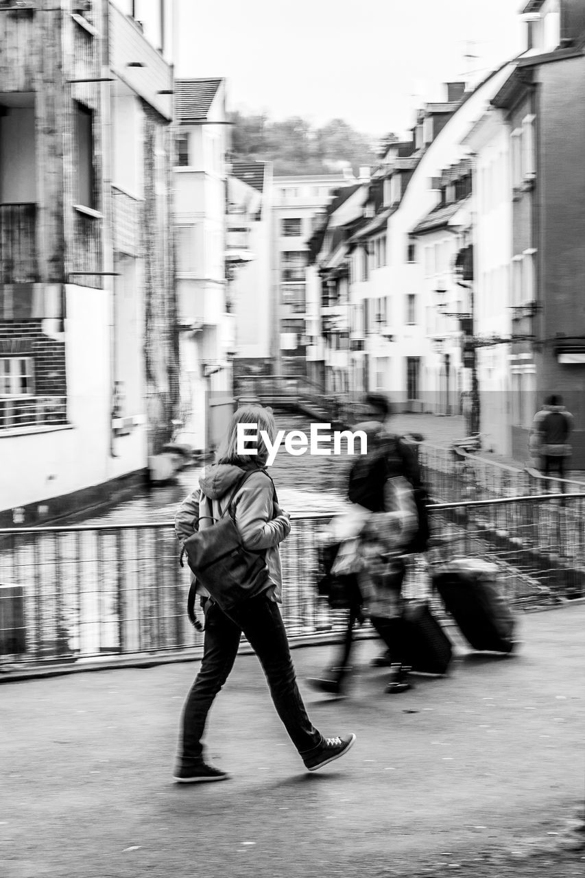 People walking on street amidst buildings in city