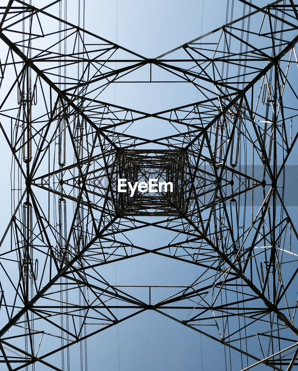 DIRECTLY BELOW SHOT OF ELECTRICITY PYLON AGAINST CLEAR SKY