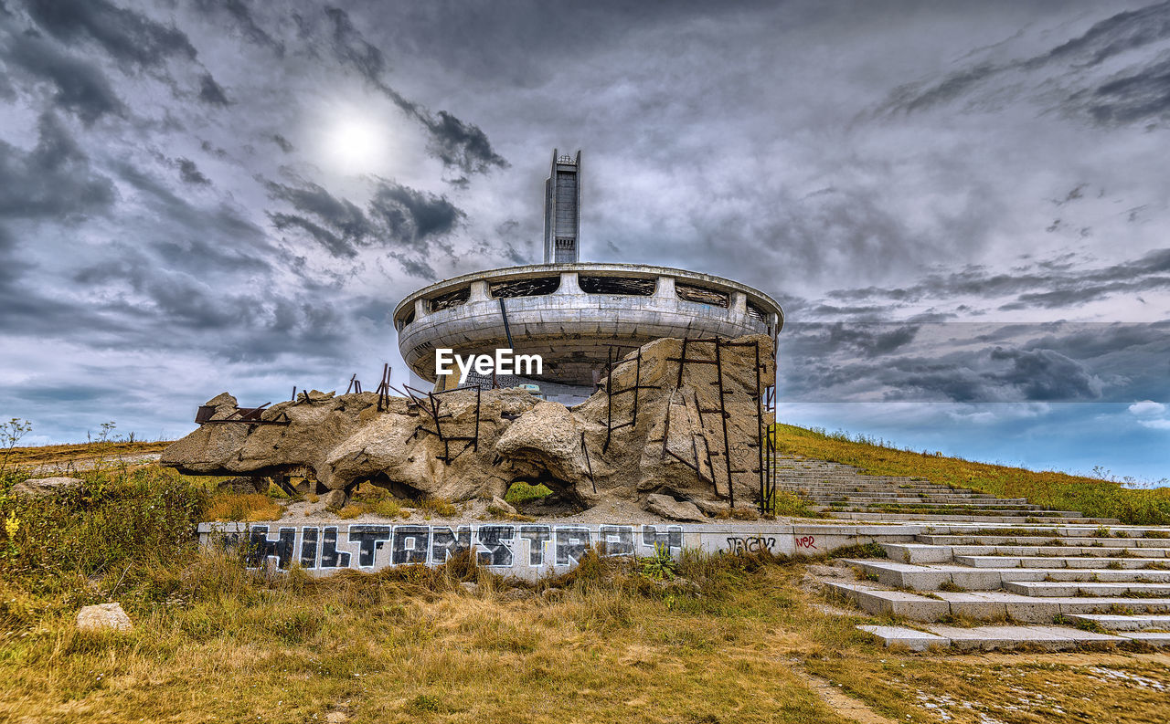Abandoned buzludzha monument tower on field against sky