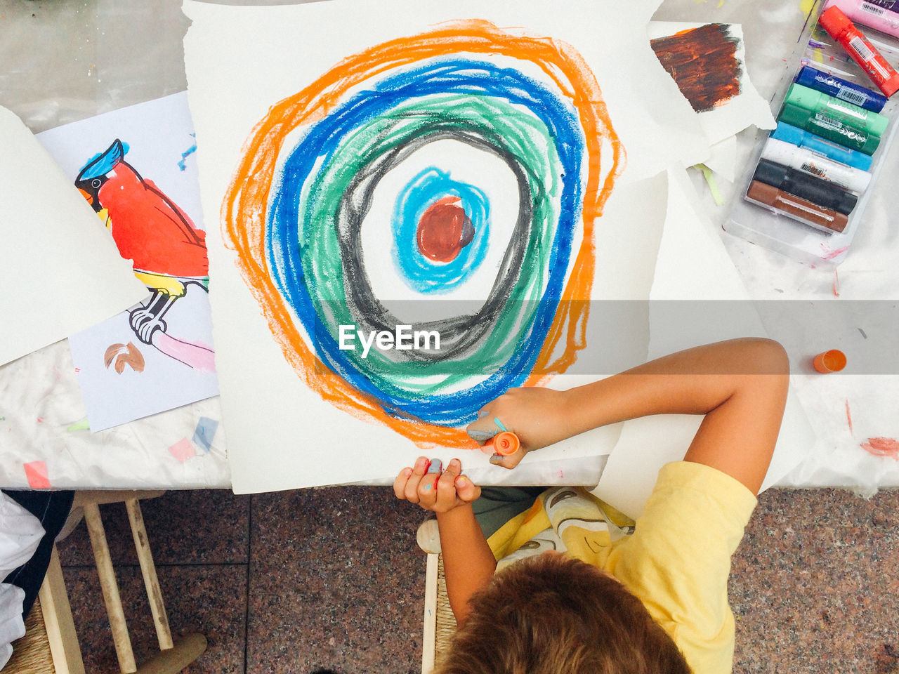 Directly above view of young boy painting