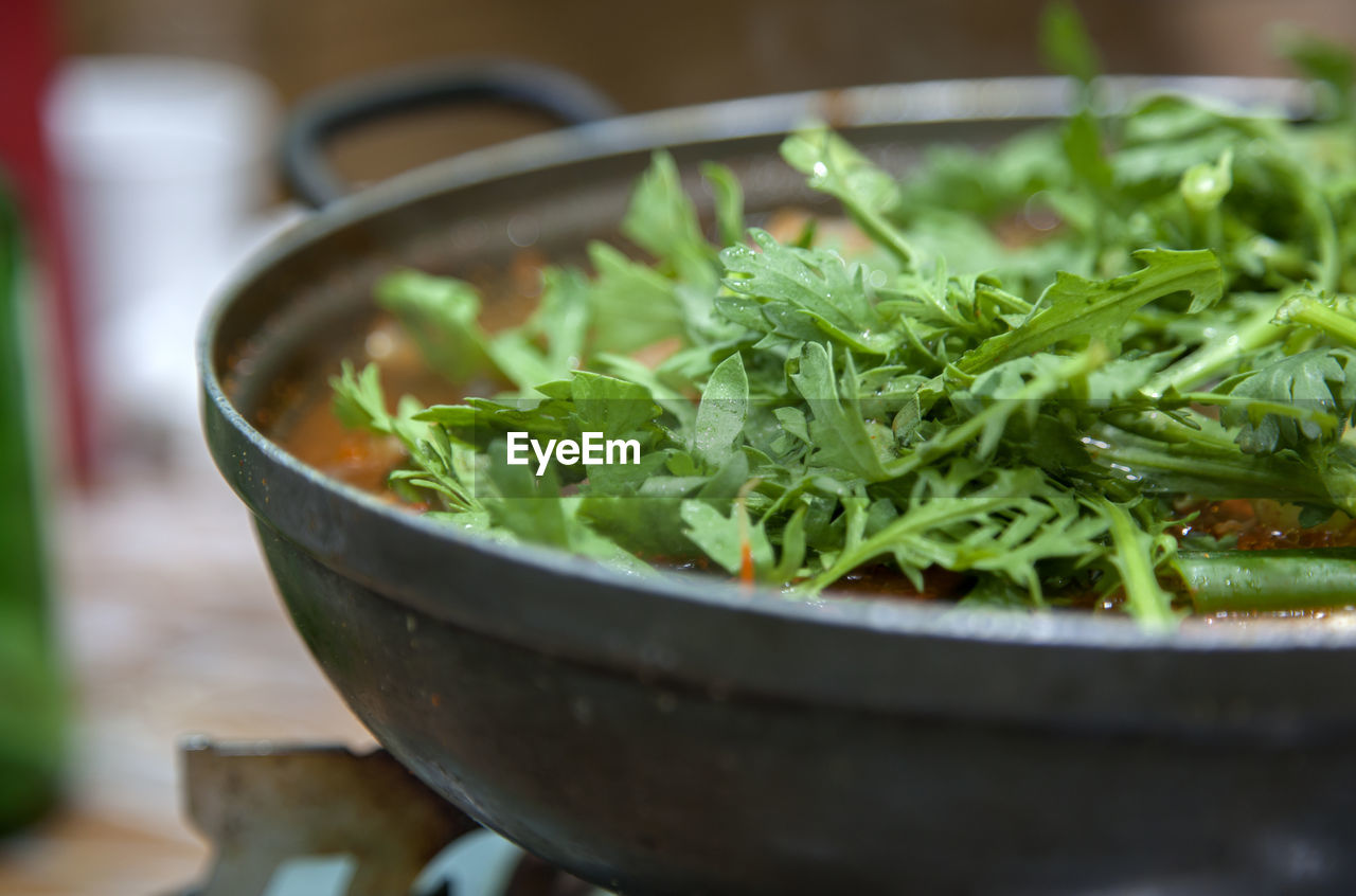 Close-up of food garnish with coriander in metal container