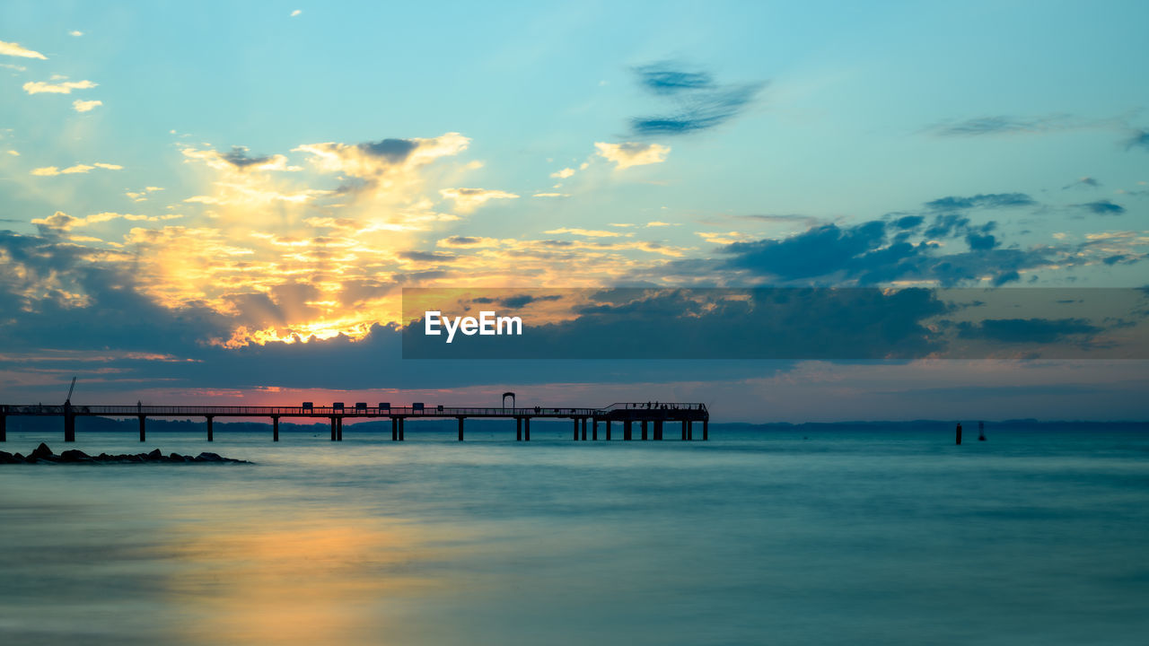 pier on sea against sky during sunset