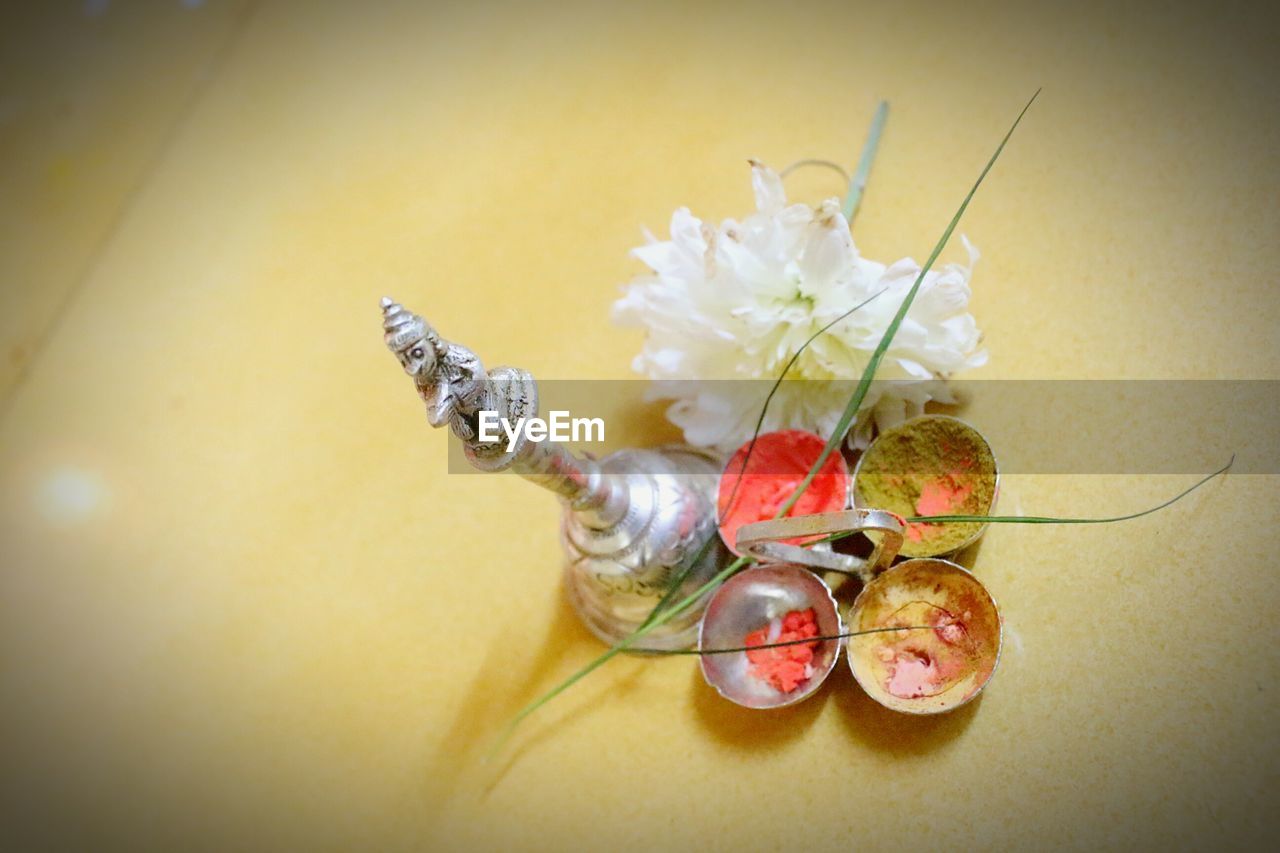 Bell with powder paints and flower on table