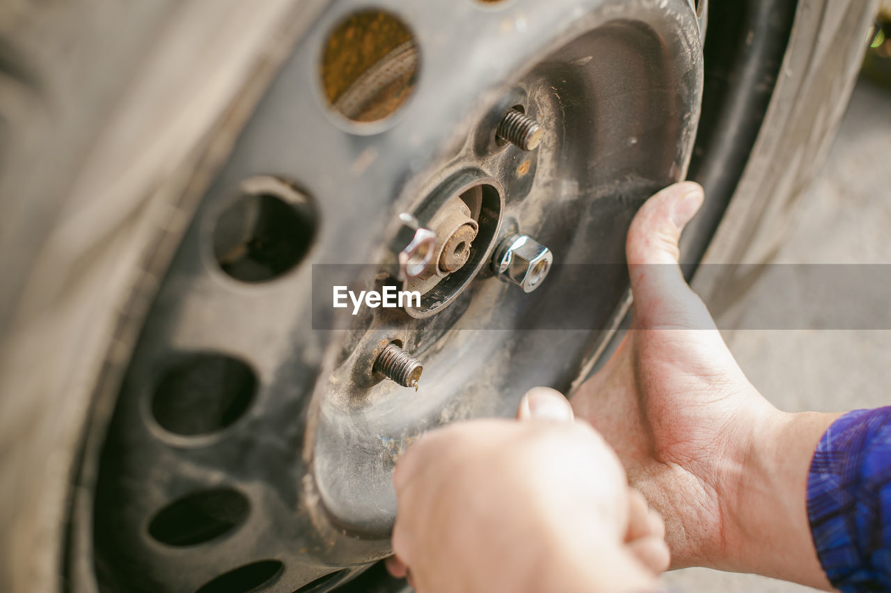 Cropped image of mechanic inflating car tire