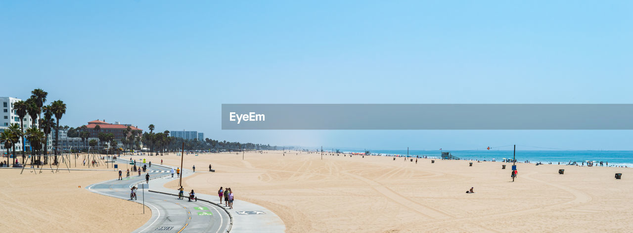 GROUP OF PEOPLE ON BEACH AGAINST CLEAR SKY