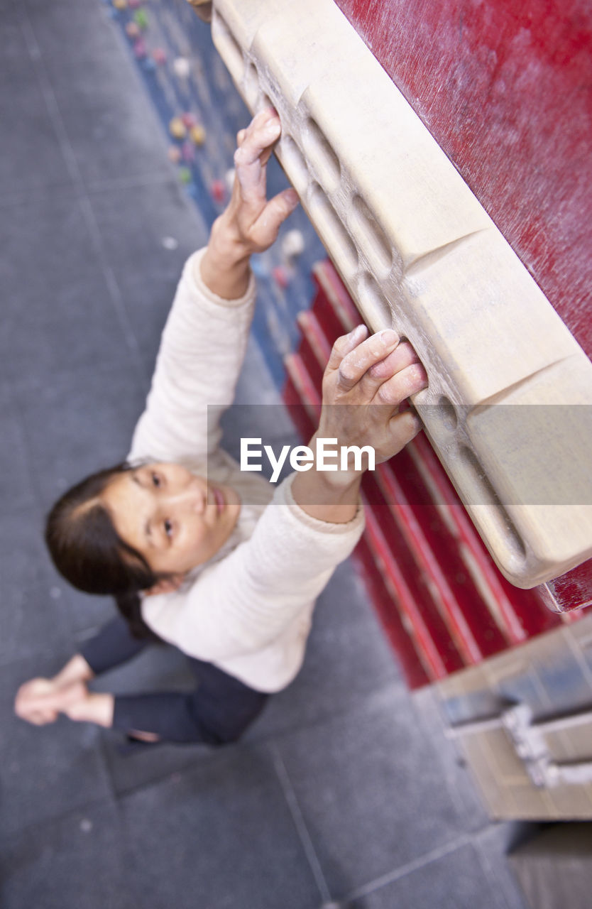 Woman training on fingerboard at indoor climbing gym