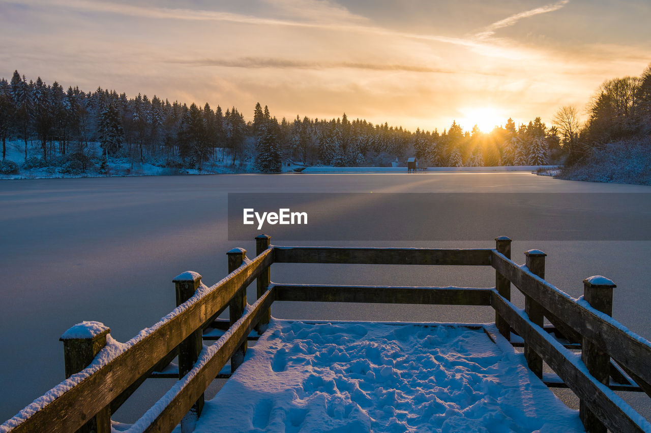 Scenic view of snow covered trees against sky during sunset