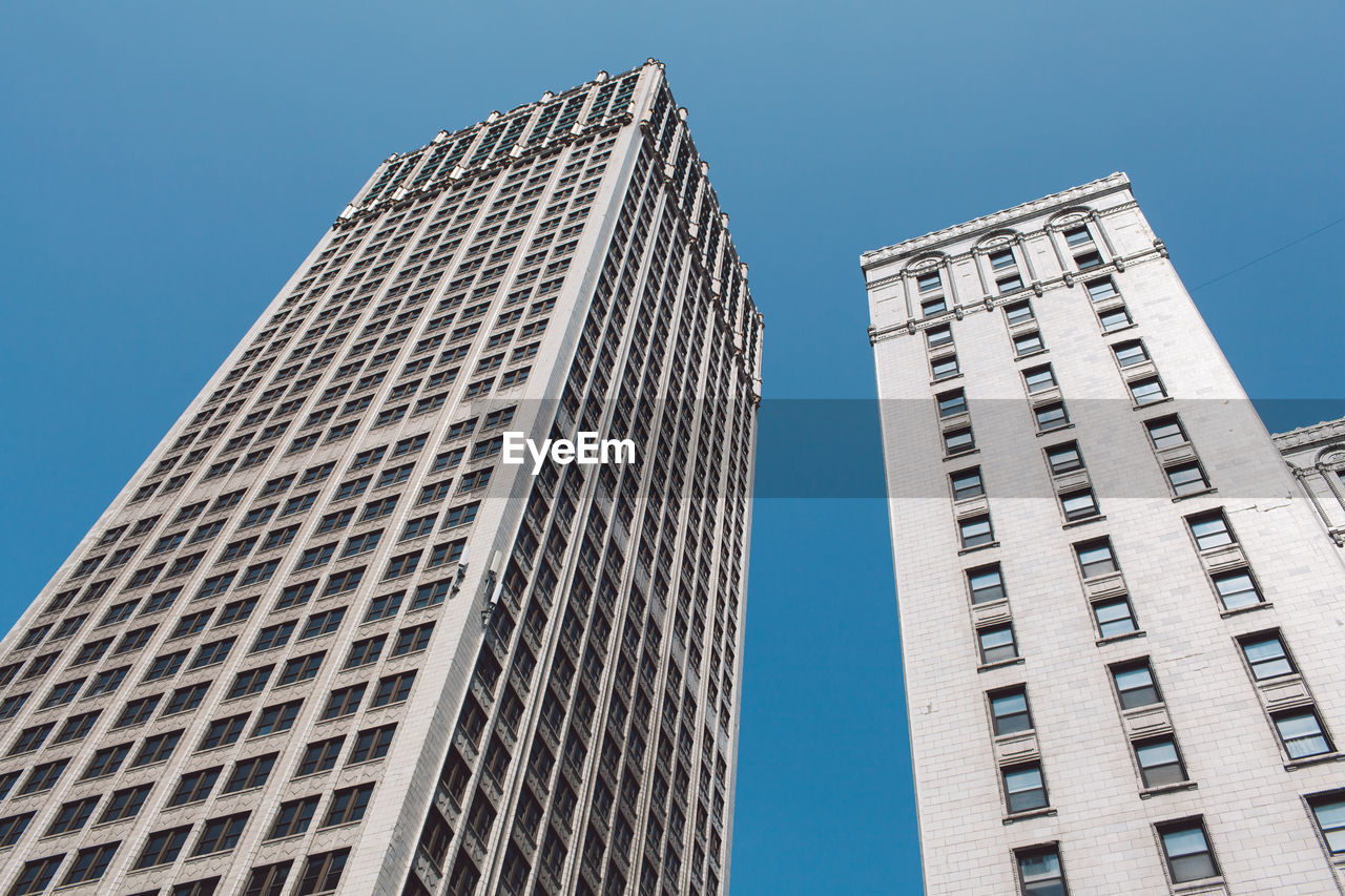 Low angle view of skyscrapers against clear blue sky