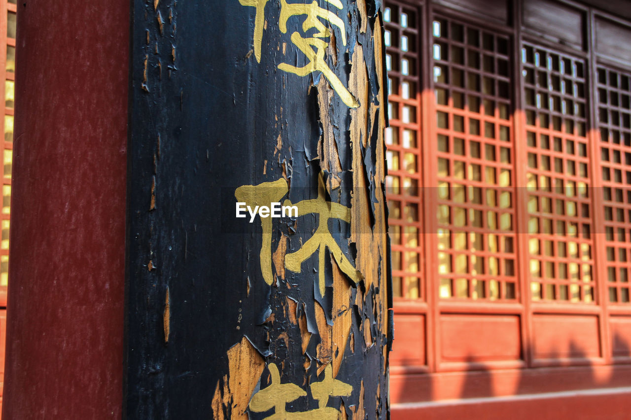 Peeled text on column on buddhist temple