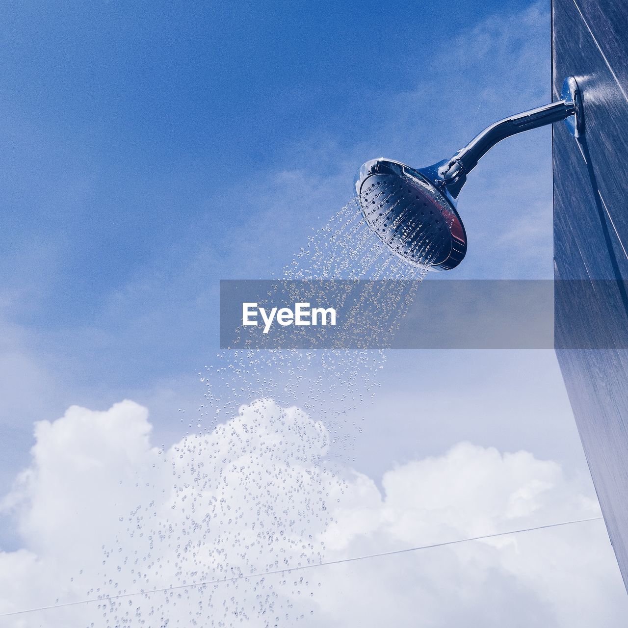 Low angle view of water falling from shower head against sky