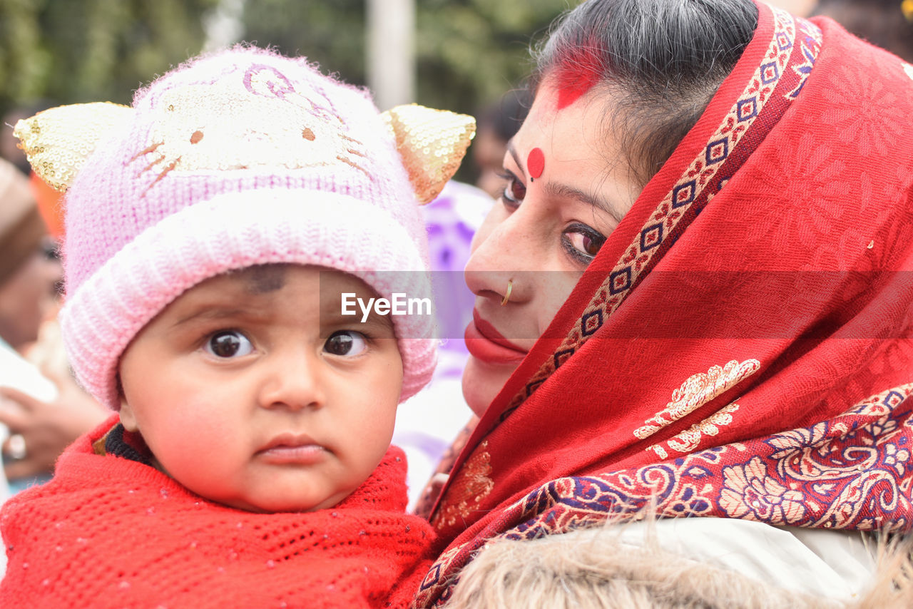 Close-up of mother carrying cute daughter