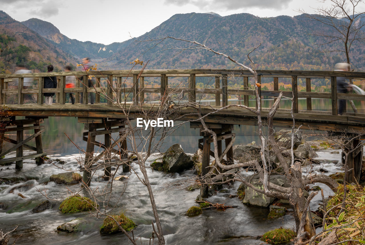 BRIDGE OVER RIVER AGAINST MOUNTAIN