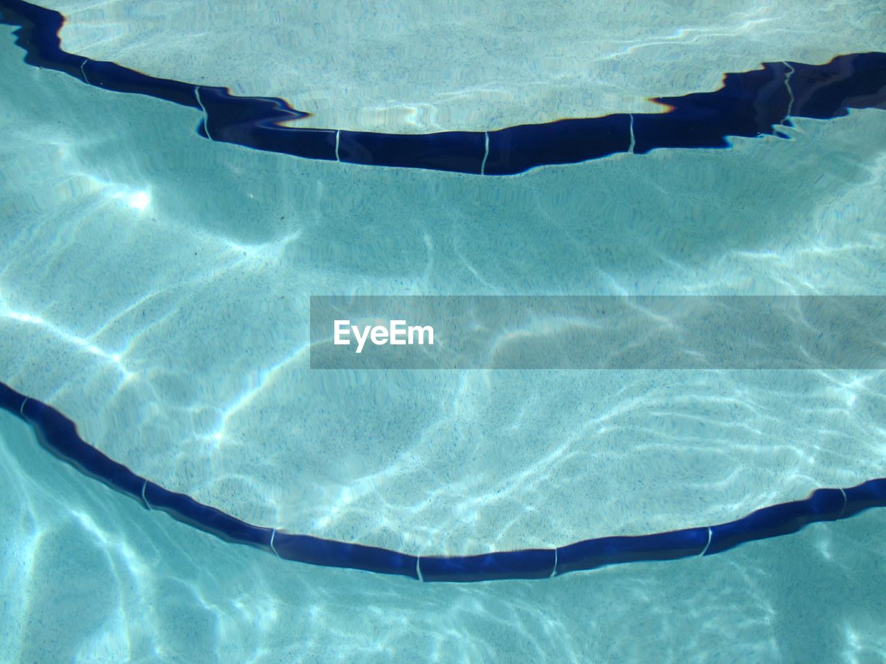 LOW SECTION OF WOMAN SWIMMING IN POOL AT SEA