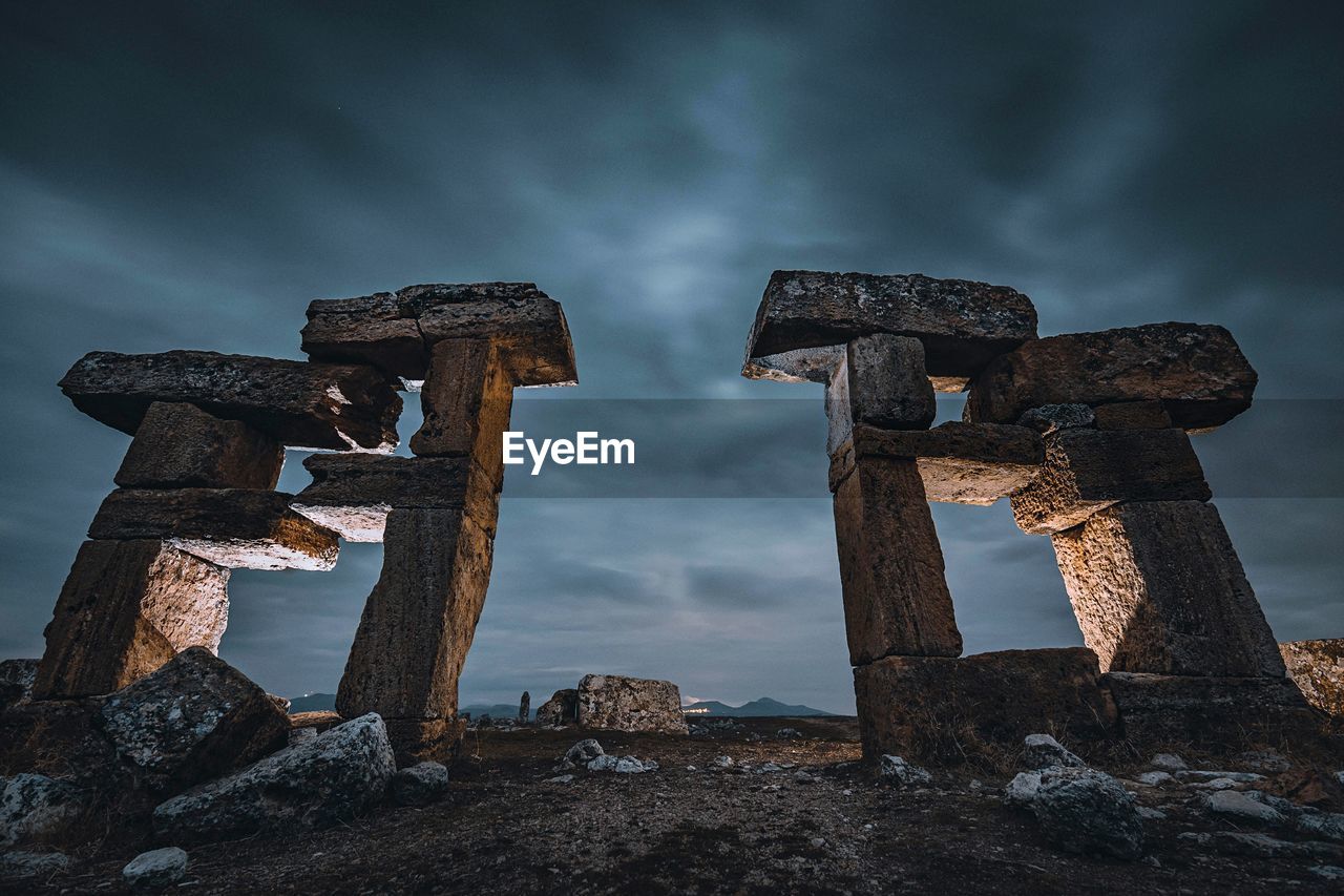 Low angle view of old ruins against cloudy sky