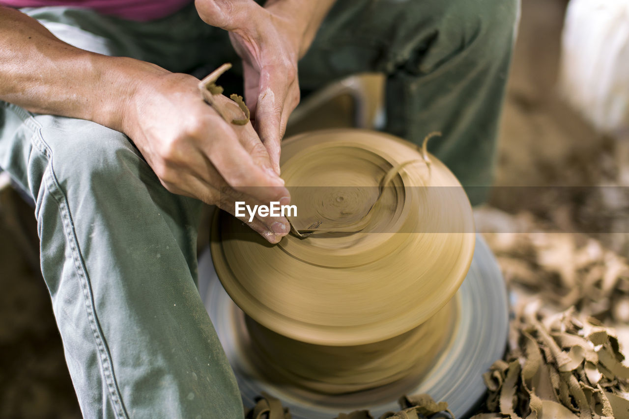 Midsection of man working with earthenware