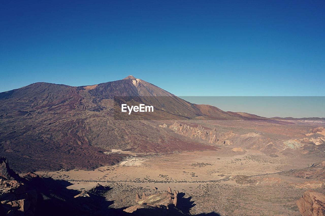 Scenic view of mountains against clear blue sky