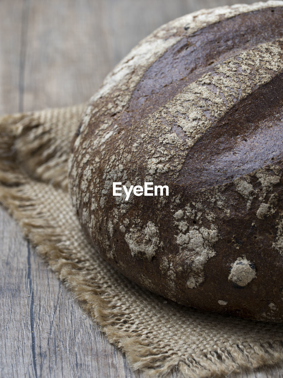 CLOSE-UP OF BREAD ON WOOD