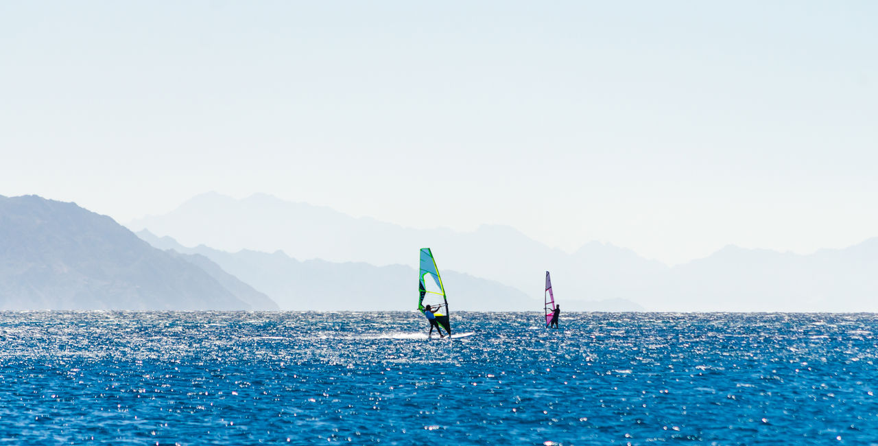 PEOPLE IN SEA AGAINST SKY