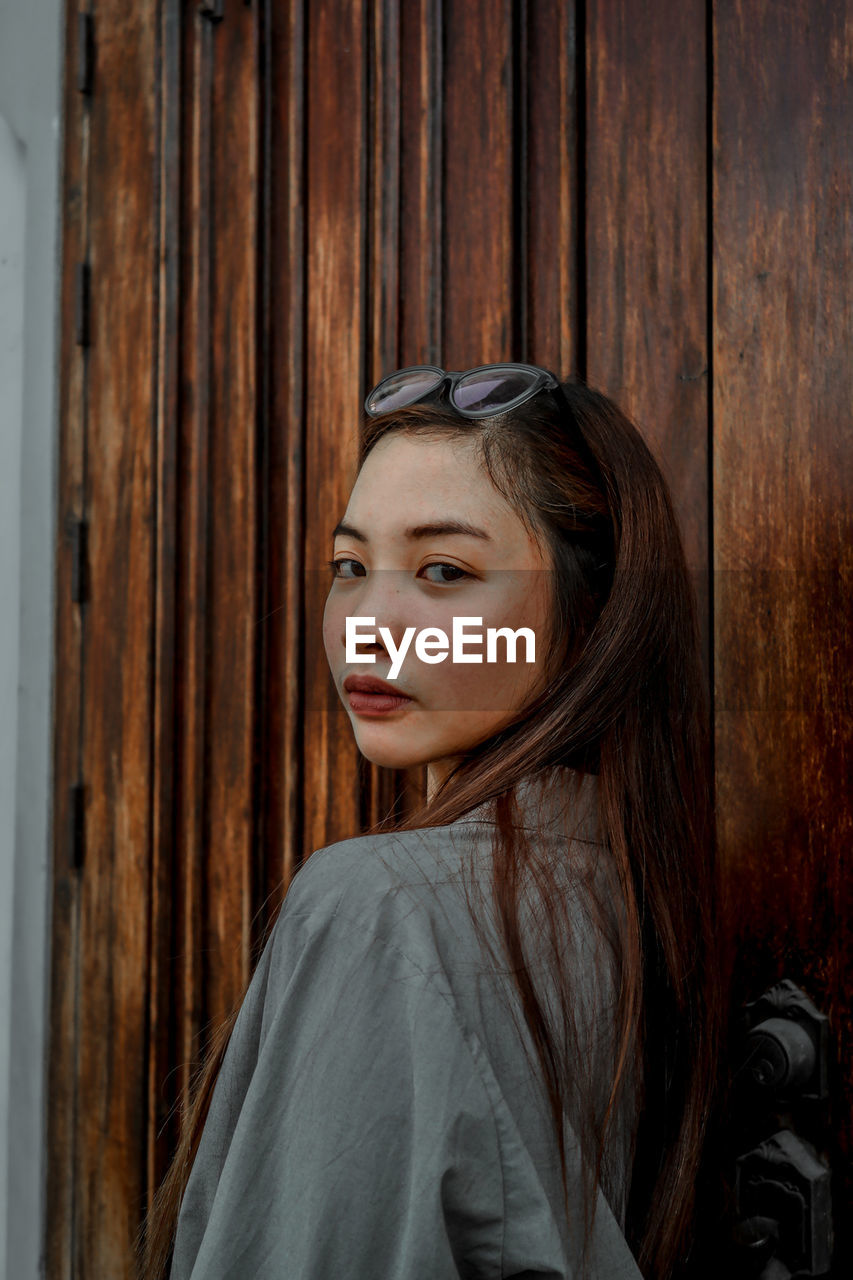 Side view portrait of young woman at home