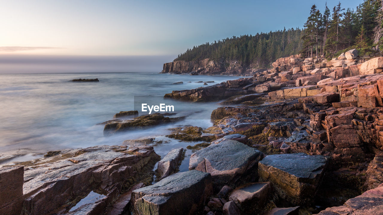 Scenic view of rocks on beach against sky
