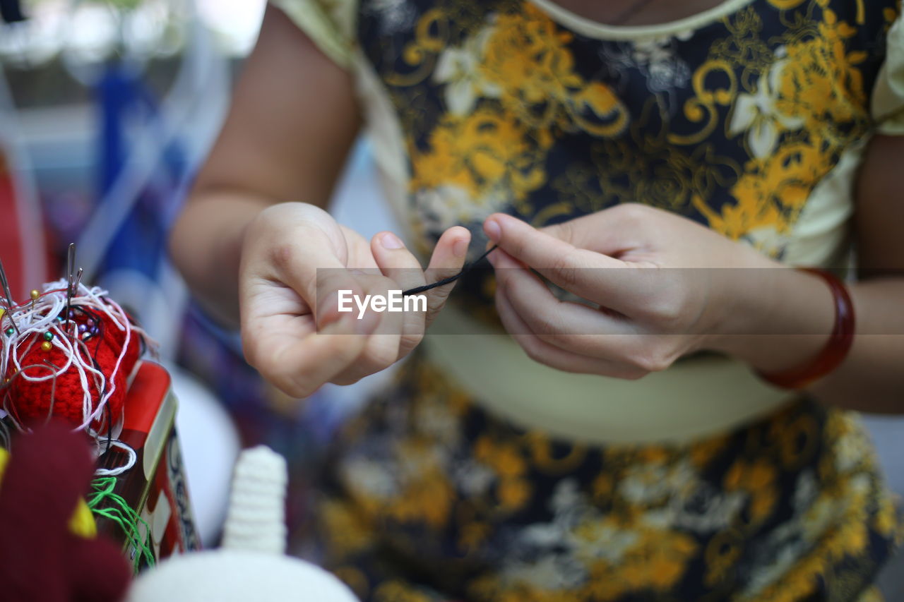 Cropped image of woman making crafts at table