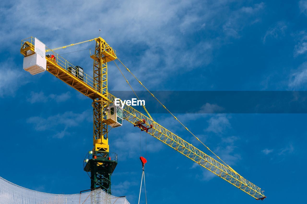 Low angle view of crane against sky