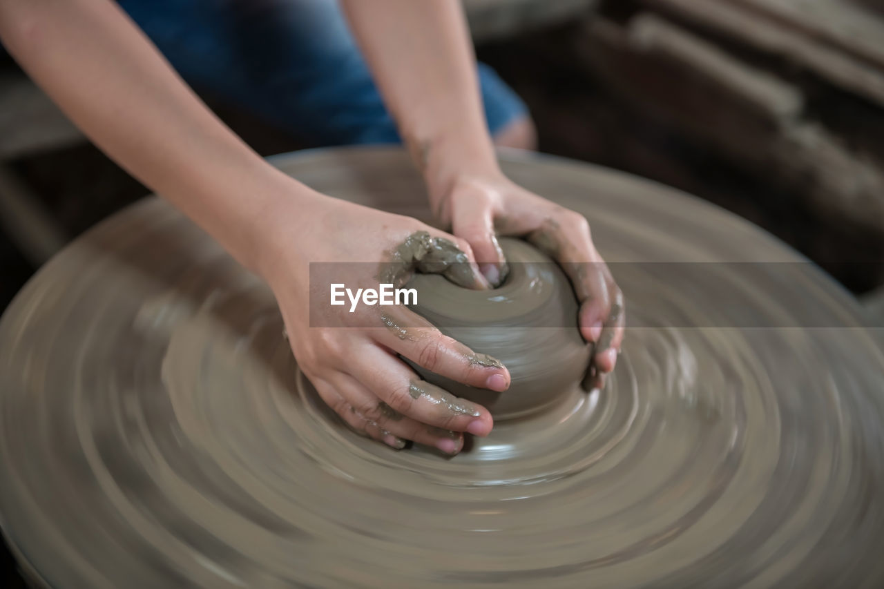 potter's wheel, skill, spinning, art, pottery, craft, hand, clay, wheel, occupation, expertise, creativity, molding a shape, making, workshop, motion, craftsperson, working, one person, ceramic, shape, adult, indoors, earthenware, mud, studio, close-up, selective focus