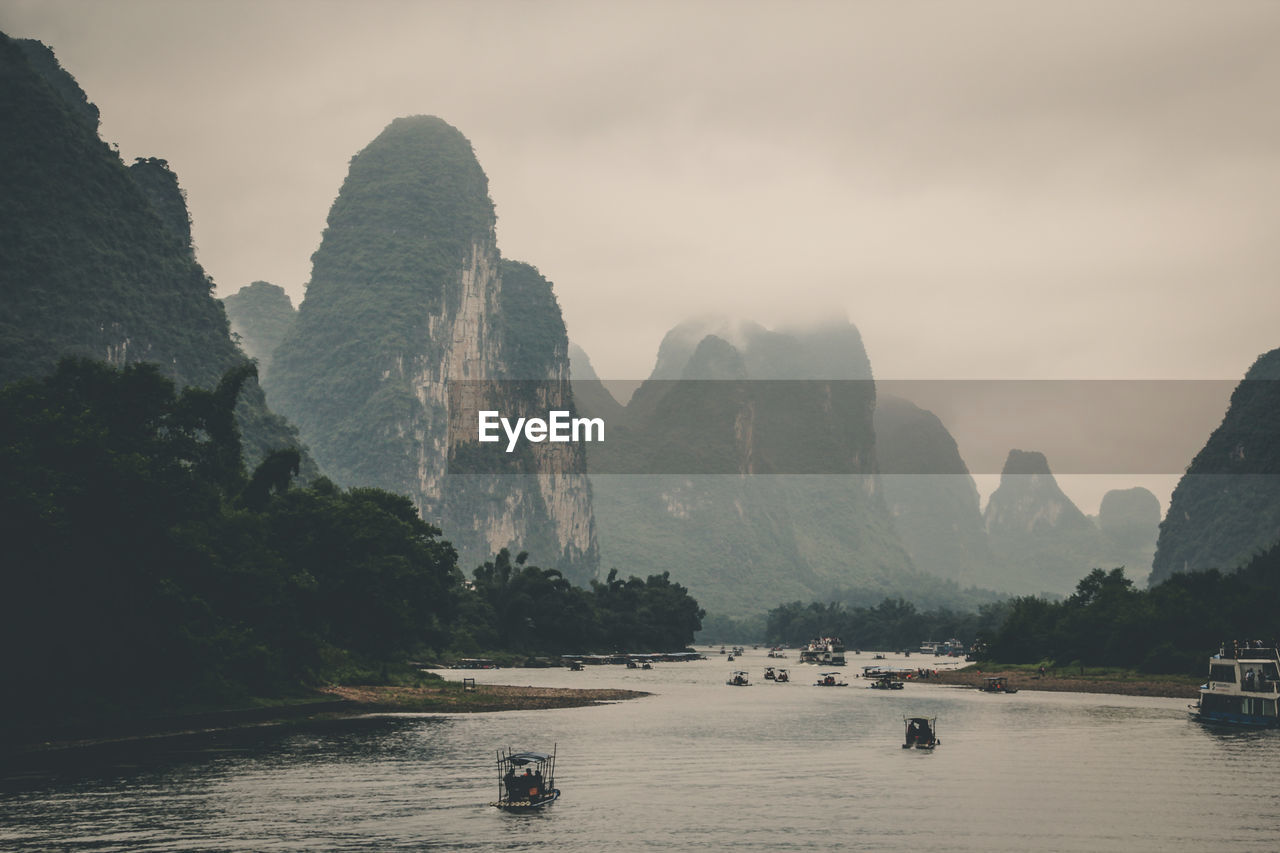 Scenic view of river and mountains against sky