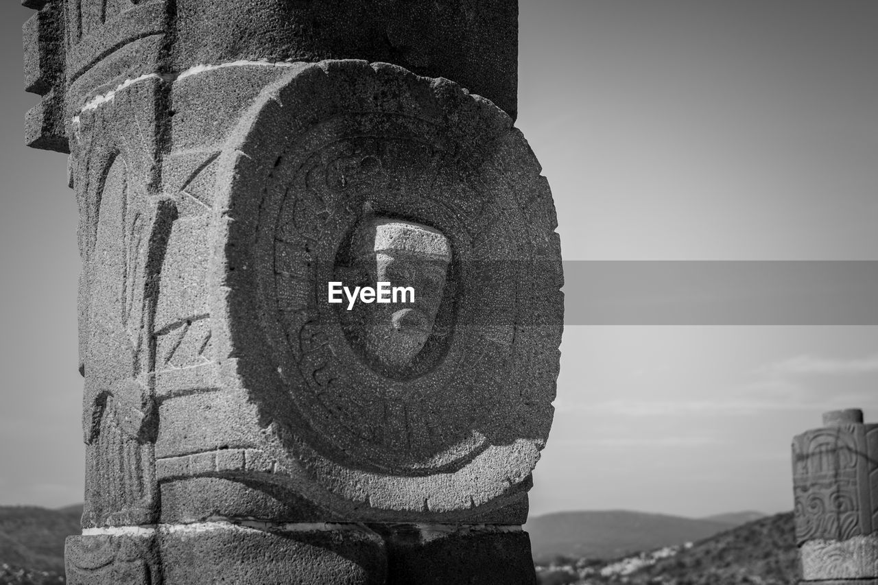 Close-up of carved stone against sky