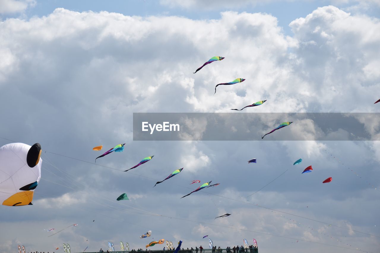 LOW ANGLE VIEW OF KITES FLYING AGAINST SKY