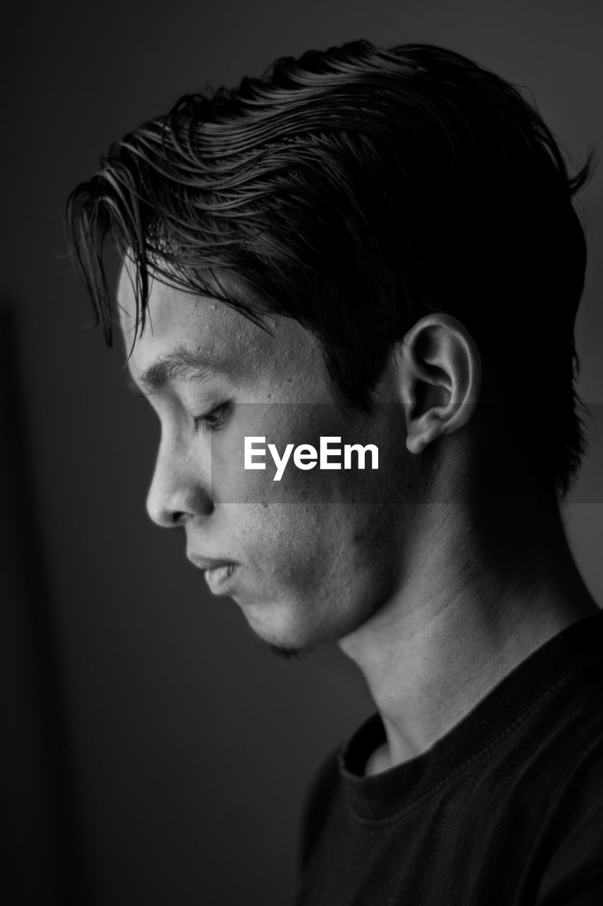 Close-up of young man on black background