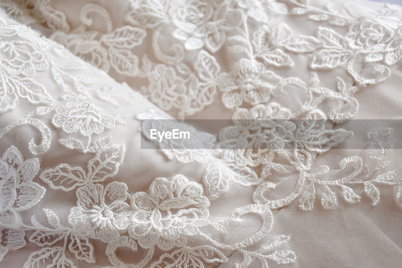 Full frame shot of white fabric and lace detail on wedding dress 