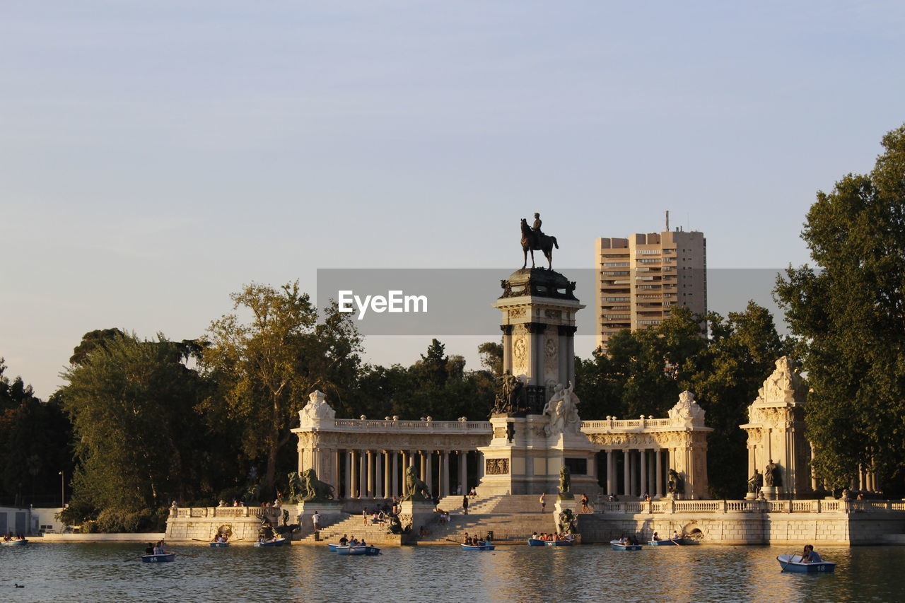 Monument to alfonso xii of spain in el retiro park, madrid, rowing boats on the lake