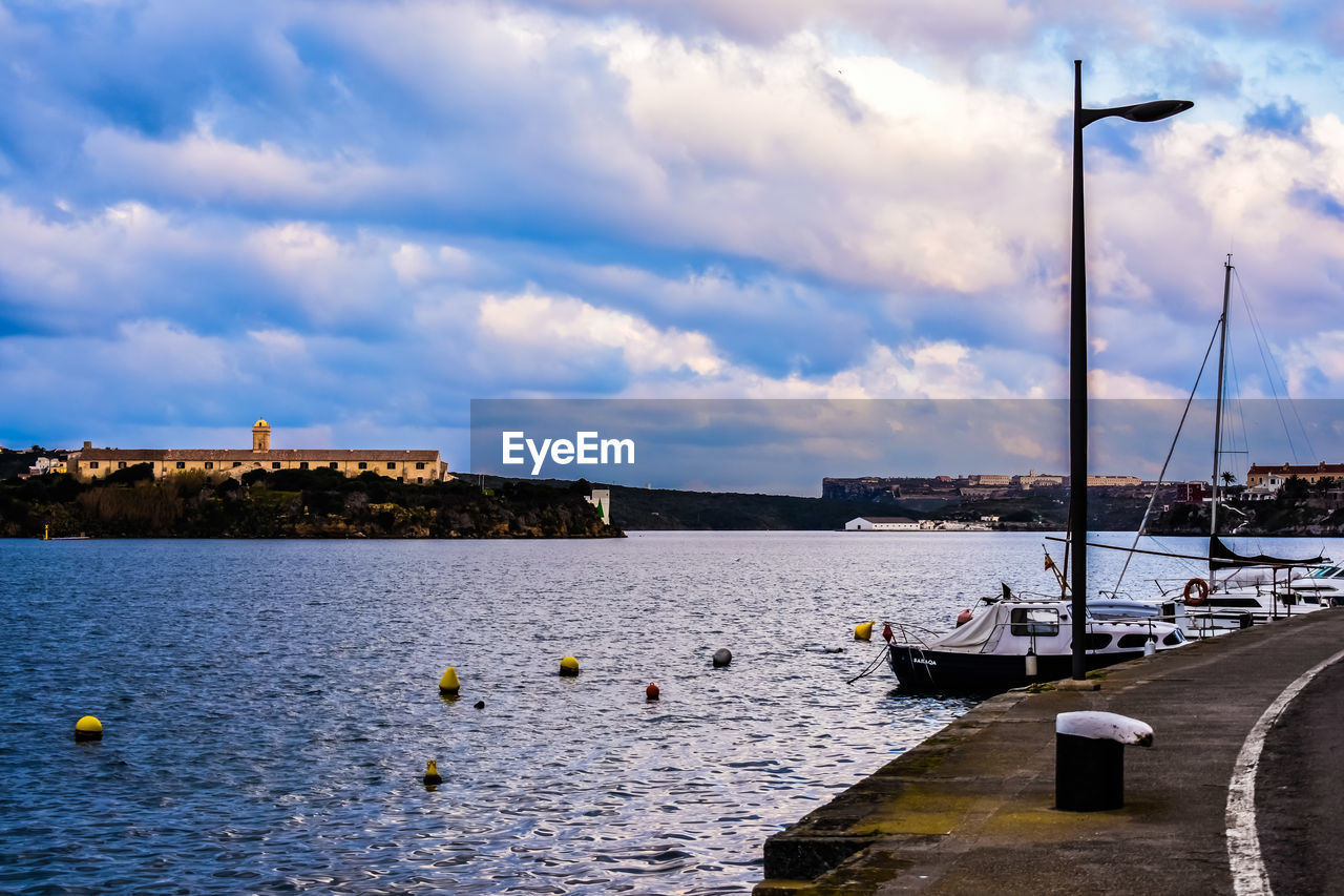 Sailboats moored on river against sky