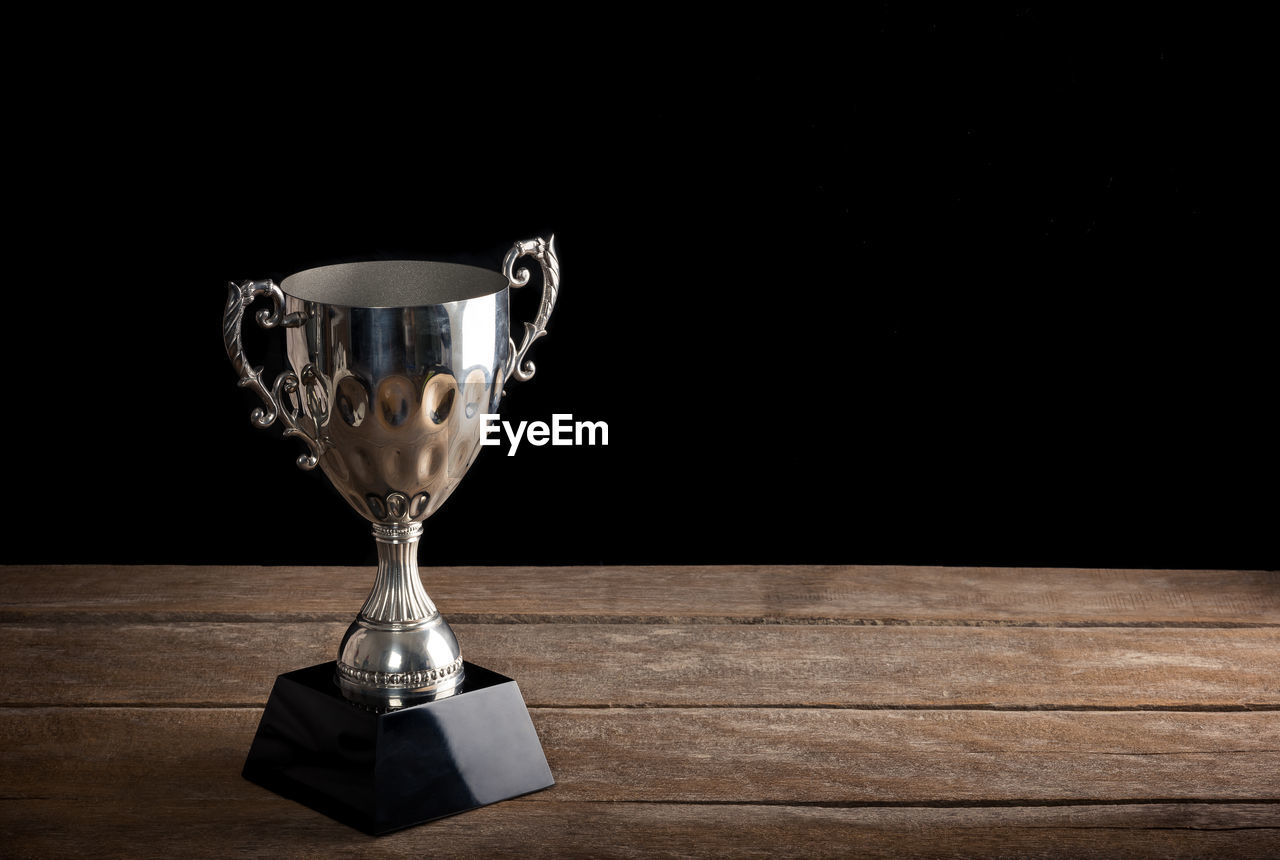 Close-up of trophy on table against black background