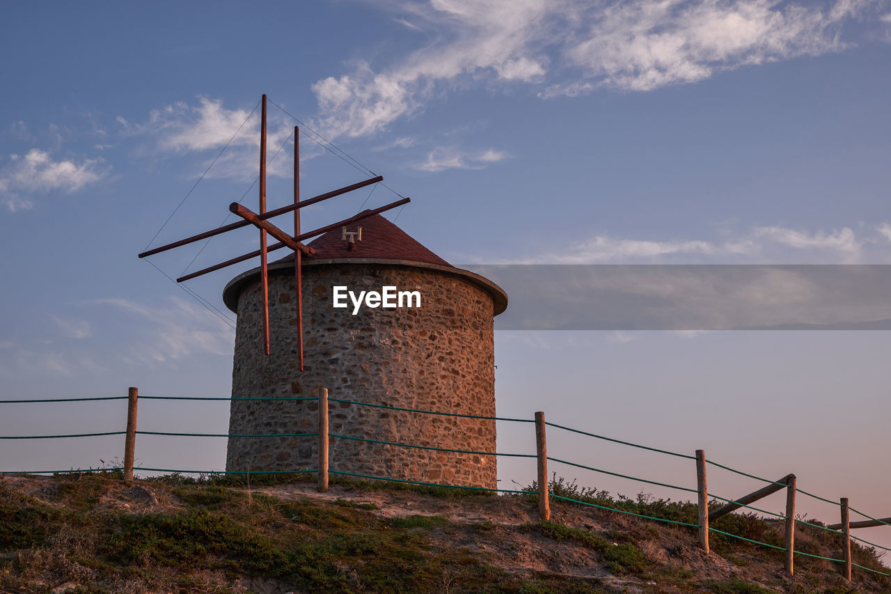 TRADITIONAL WINDMILL AGAINST CLOUDY SKY