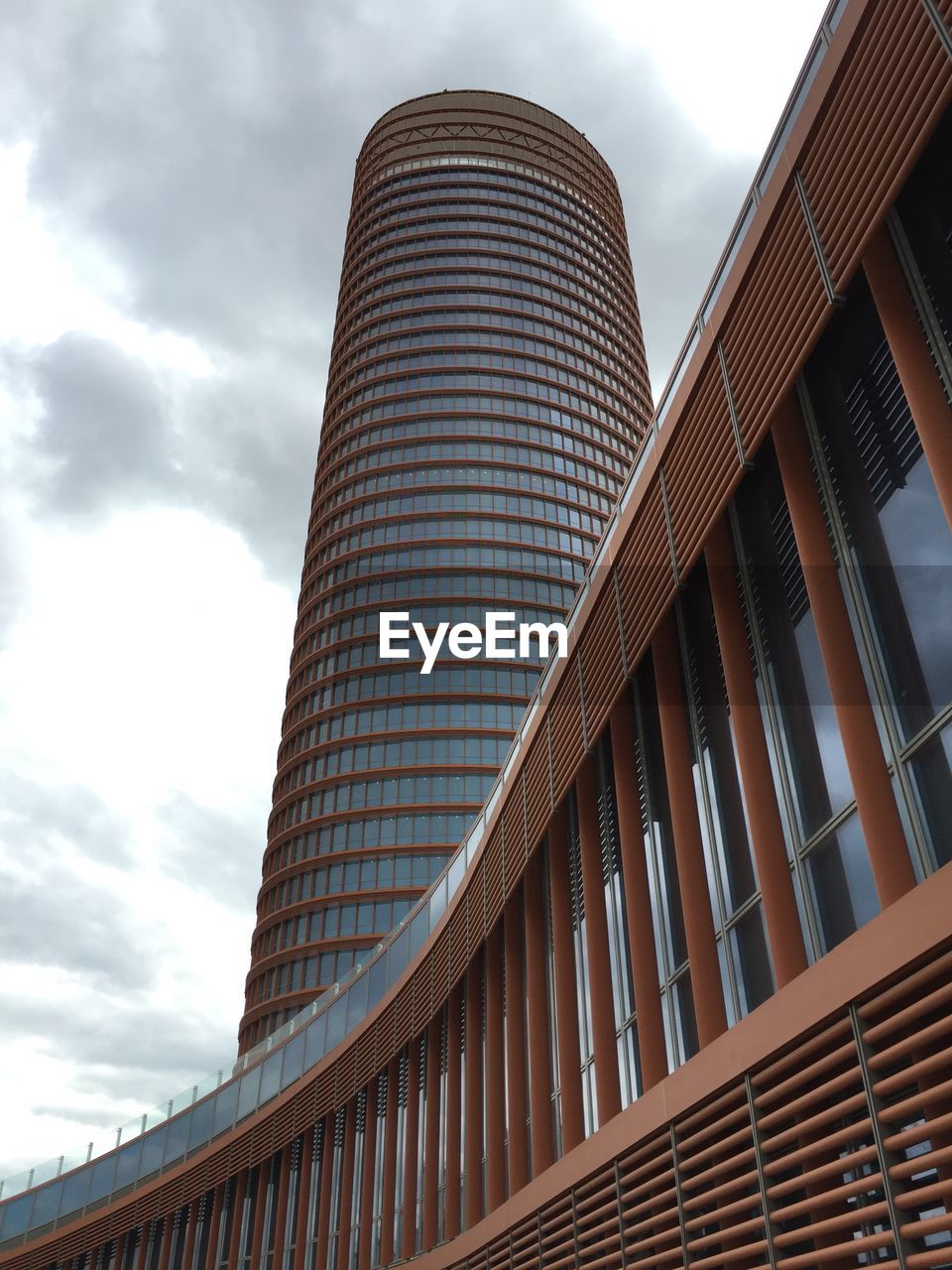 LOW ANGLE VIEW OF MODERN BUILDINGS AGAINST CLOUDY SKY