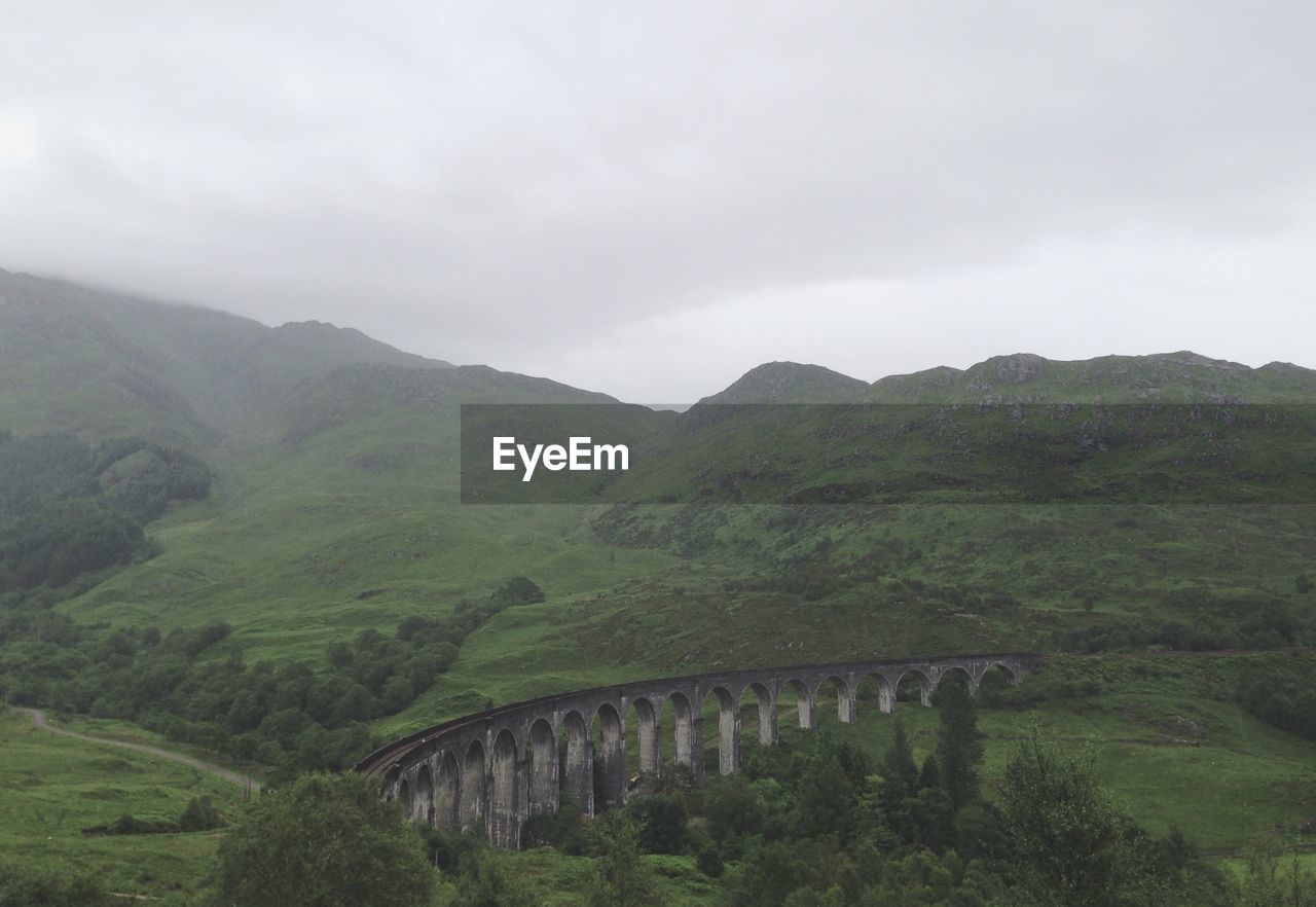 Scenic view of mountains against cloudy sky