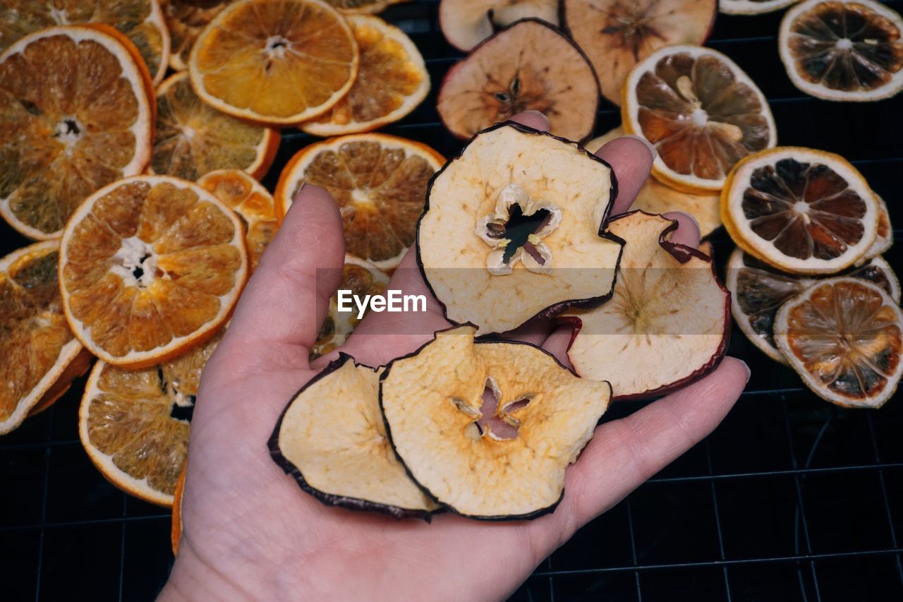 Close up of hand holding slices of dried apples