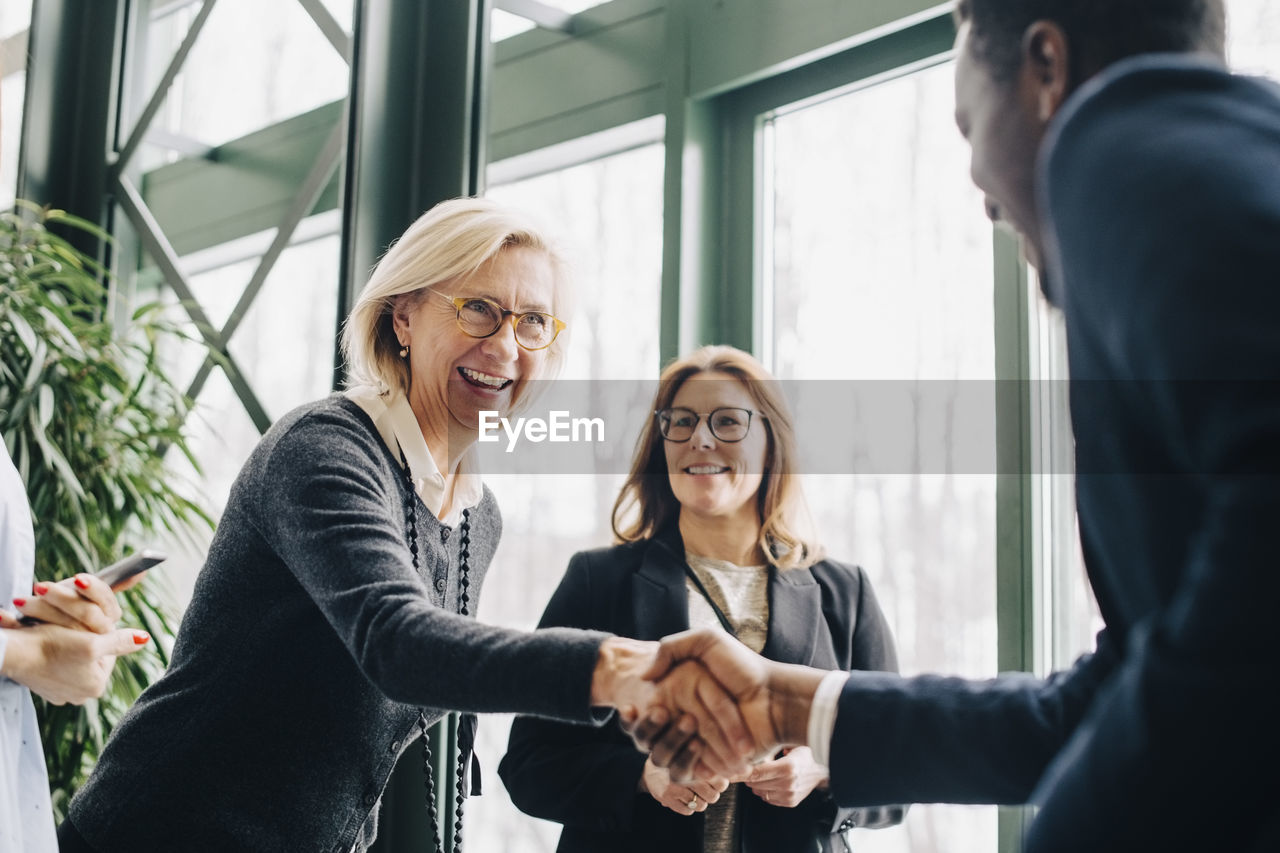 Senior businesswoman greeting colleagues during conference