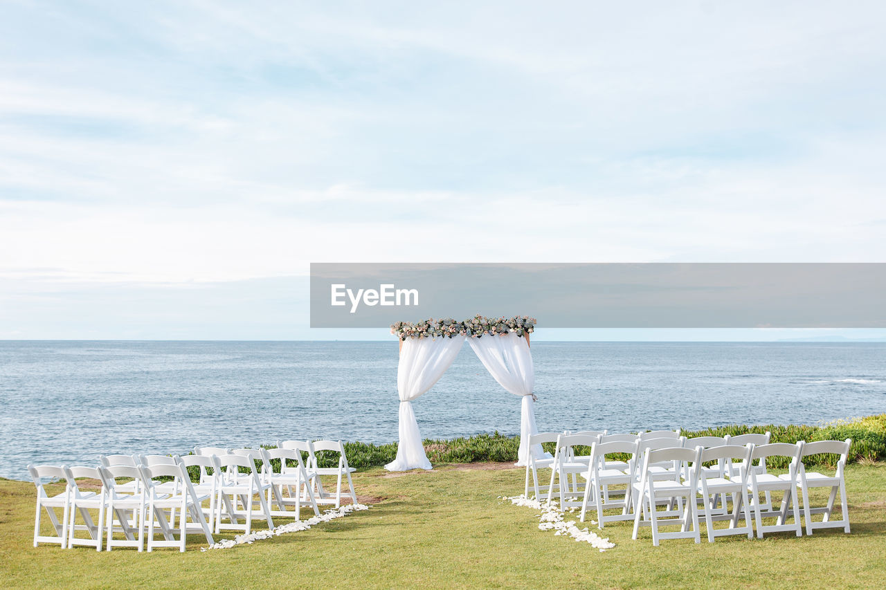 Beach destination wedding - ceremony arch and chairs on the beach