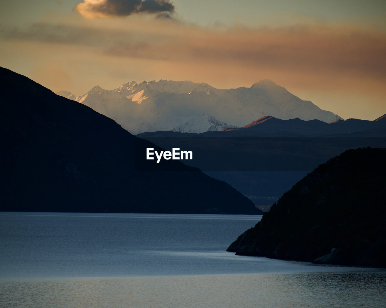 Scenic view of  lake wakatipu and mountains against sky during sunset. queenstown, new zealand.