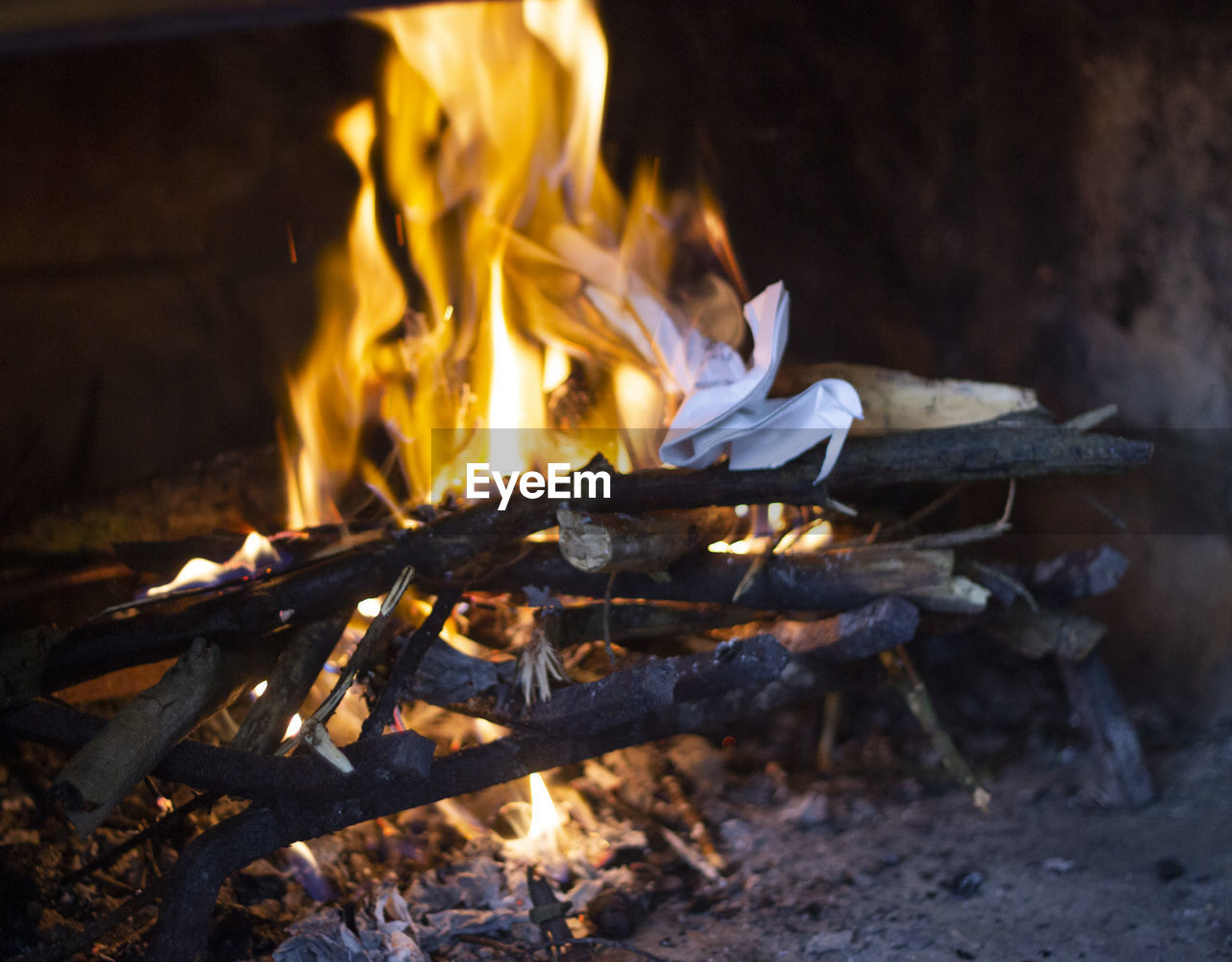 Close-up of bonfire on log at night