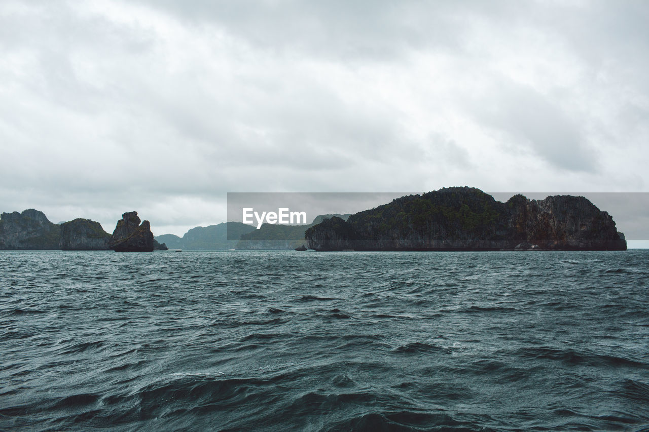 Scenic view of sea and mountains against sky