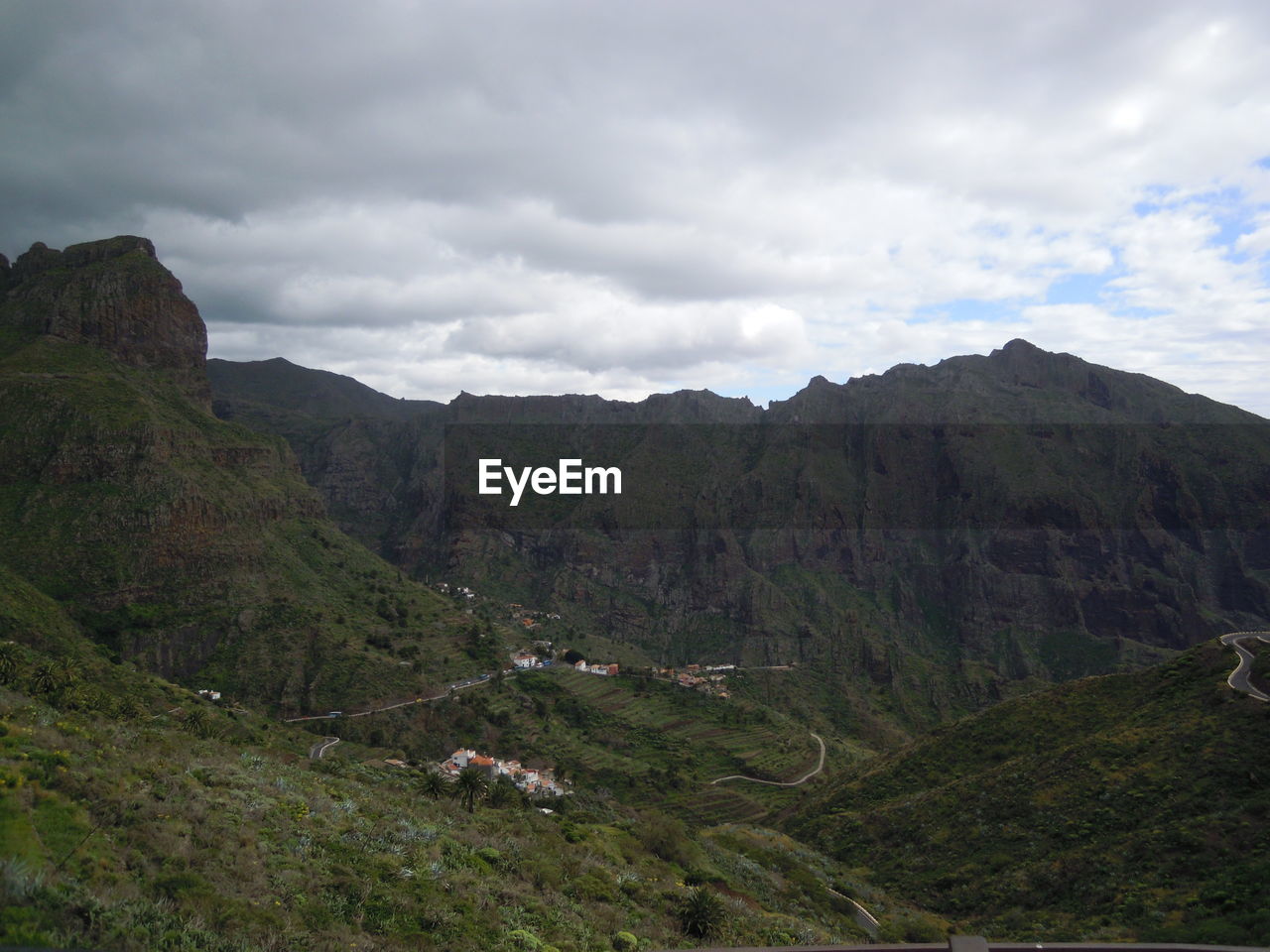 SCENIC VIEW OF MOUNTAIN RANGE AND CLOUDY SKY