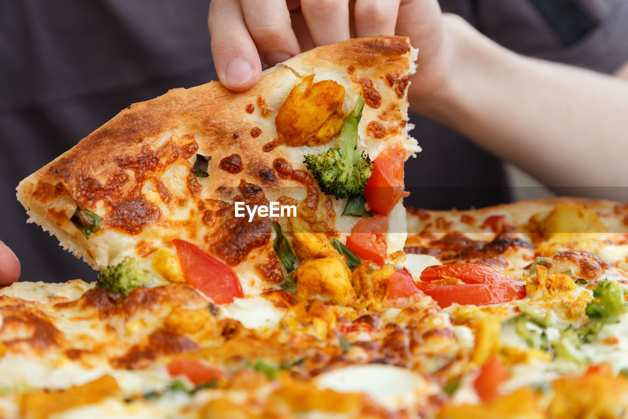 Cropped hands eating pizza