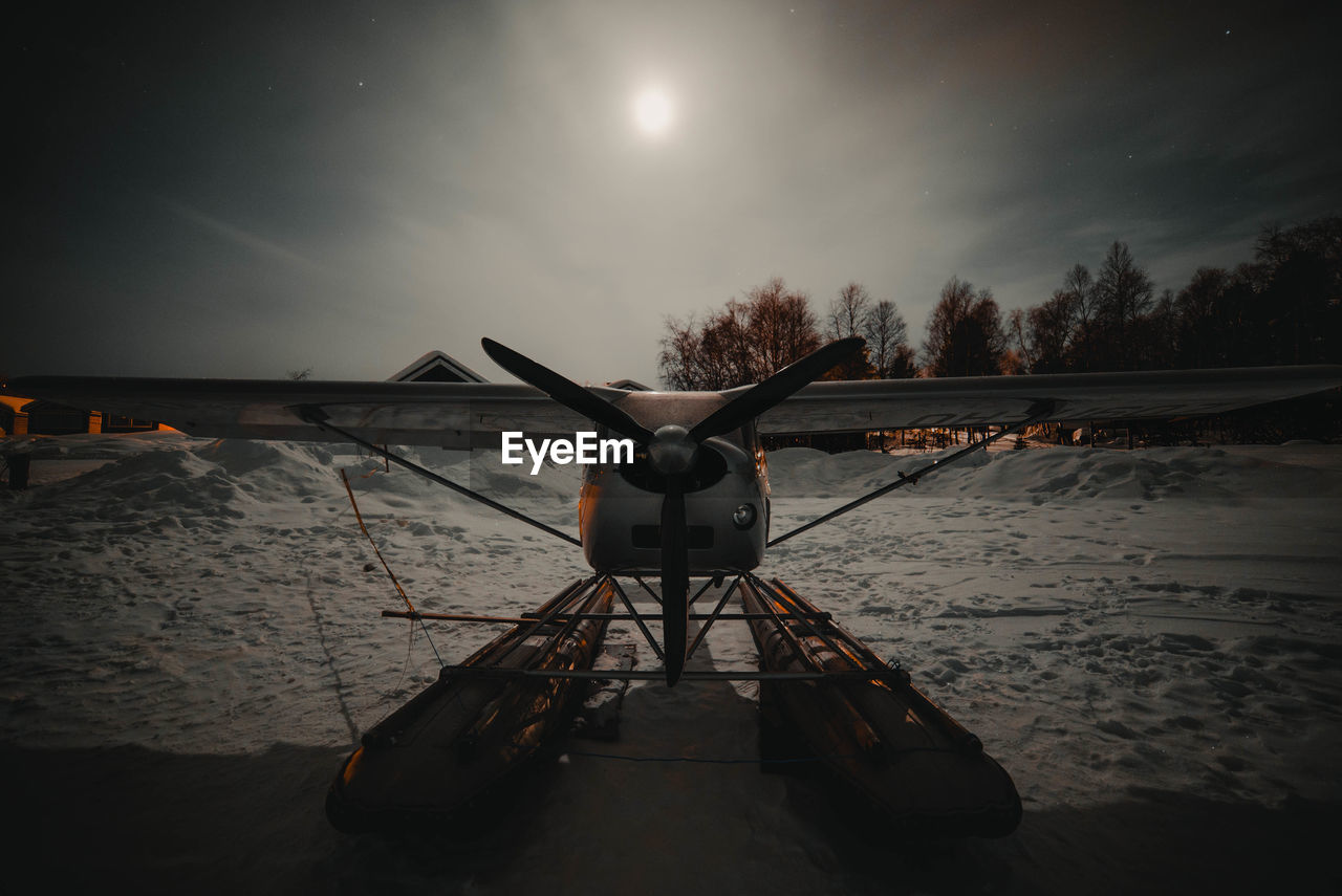 Biplane against sky at night during winter